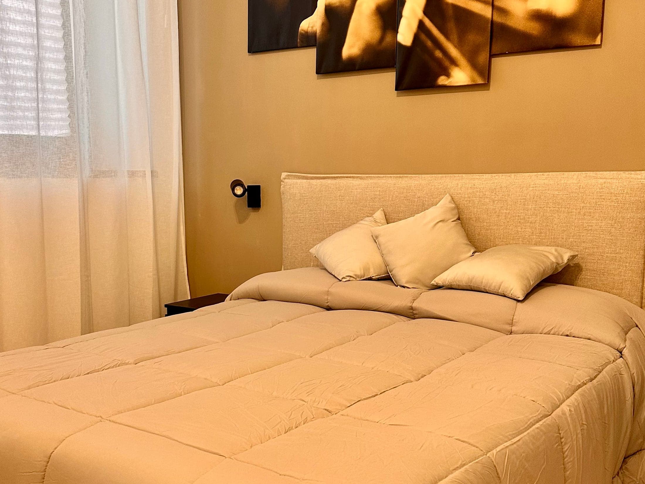 La zona notte di Nina's Home, con testata imbottita e luce calda